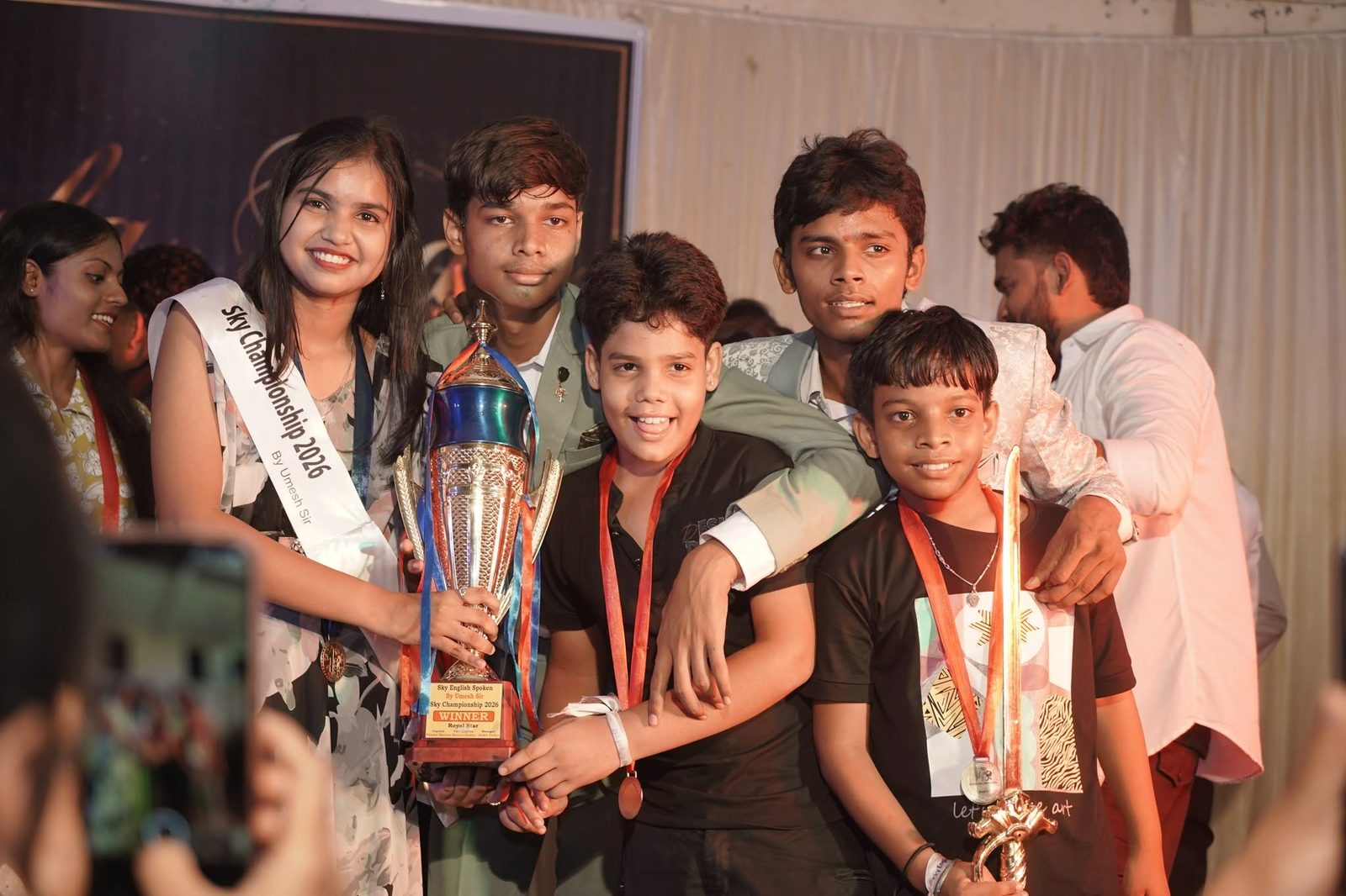Young learners celebrating an achievement with a trophy